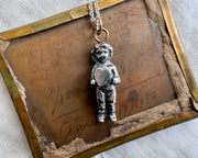 doll holding a heart pendant