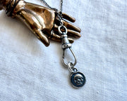 dog clip holding a tiny skull charm