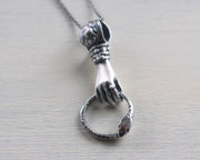 hand holding ouroboros necklace