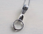 hand holding ouroboros necklace