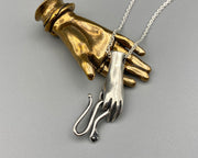 hand holding serpent necklace