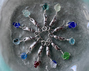 tiny crab claw holding sea glass pendant