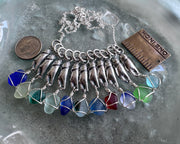 tiny crab claw holding sea glass pendant