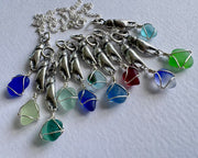 tiny crab claw holding sea glass pendant