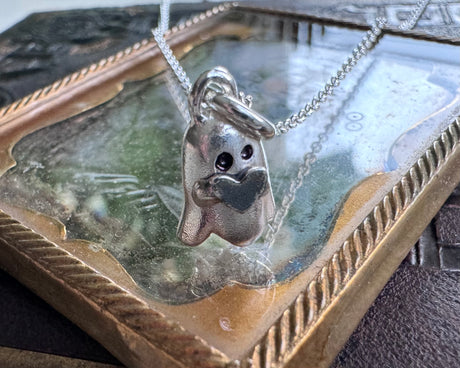 ghost holding a heart necklace