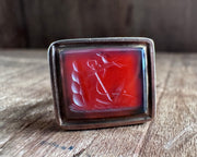 a little bird resting on an anchor leaning against a rock - antique fob wax seal