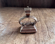 a little bird resting on an anchor leaning against a rock - antique fob wax seal