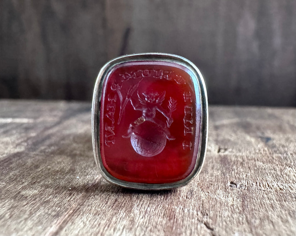 a winged cherub on top of the world fob seal - I RIDE TRIUMPHANT