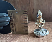 a winged cherub on top of the world fob seal - I RIDE TRIUMPHANT