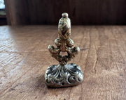 a winged cherub on top of the world fob seal - I RIDE TRIUMPHANT