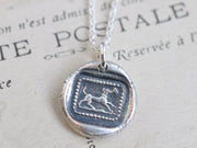 dog carrying a letter wax seal necklace